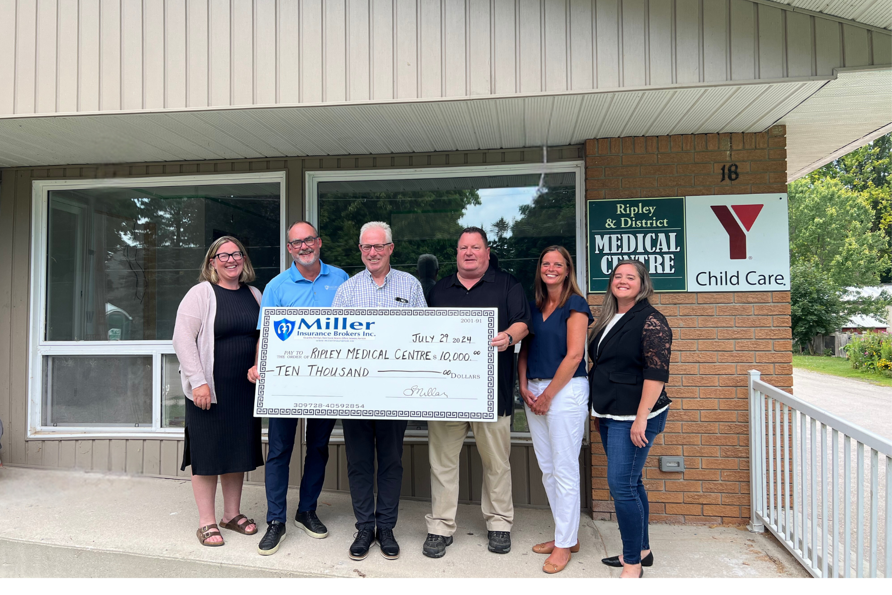 Figure 1: Amanda Farrell Walsh, Todd Farrell, Mike Fair, Dave Young, Laura Lambert, and Michelle Goetz in front of the Ripley Medical Centre.